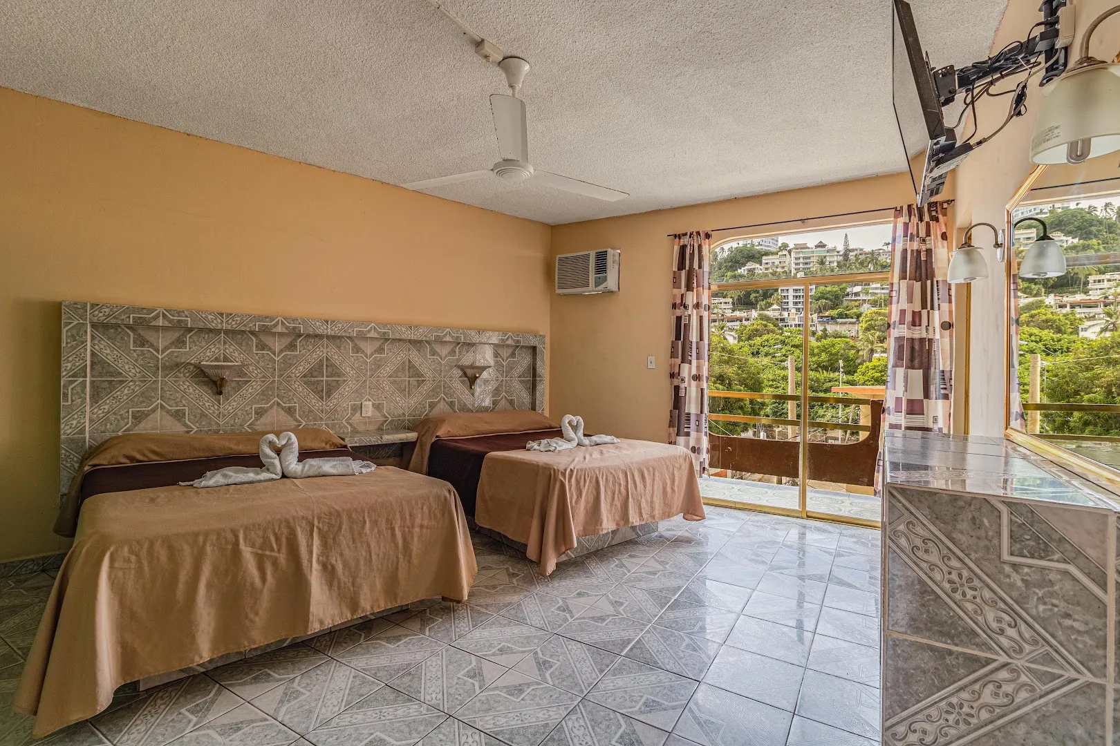 Habitación con dos camas y ventana con vista a la vegetación